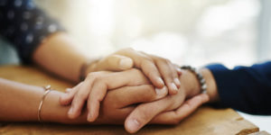 Closeup shot of two unrecognizable people holding hands in comfort