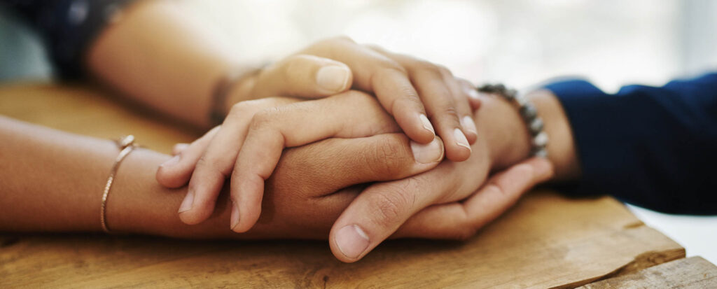 Closeup shot of two unrecognizable people holding hands in comfort
